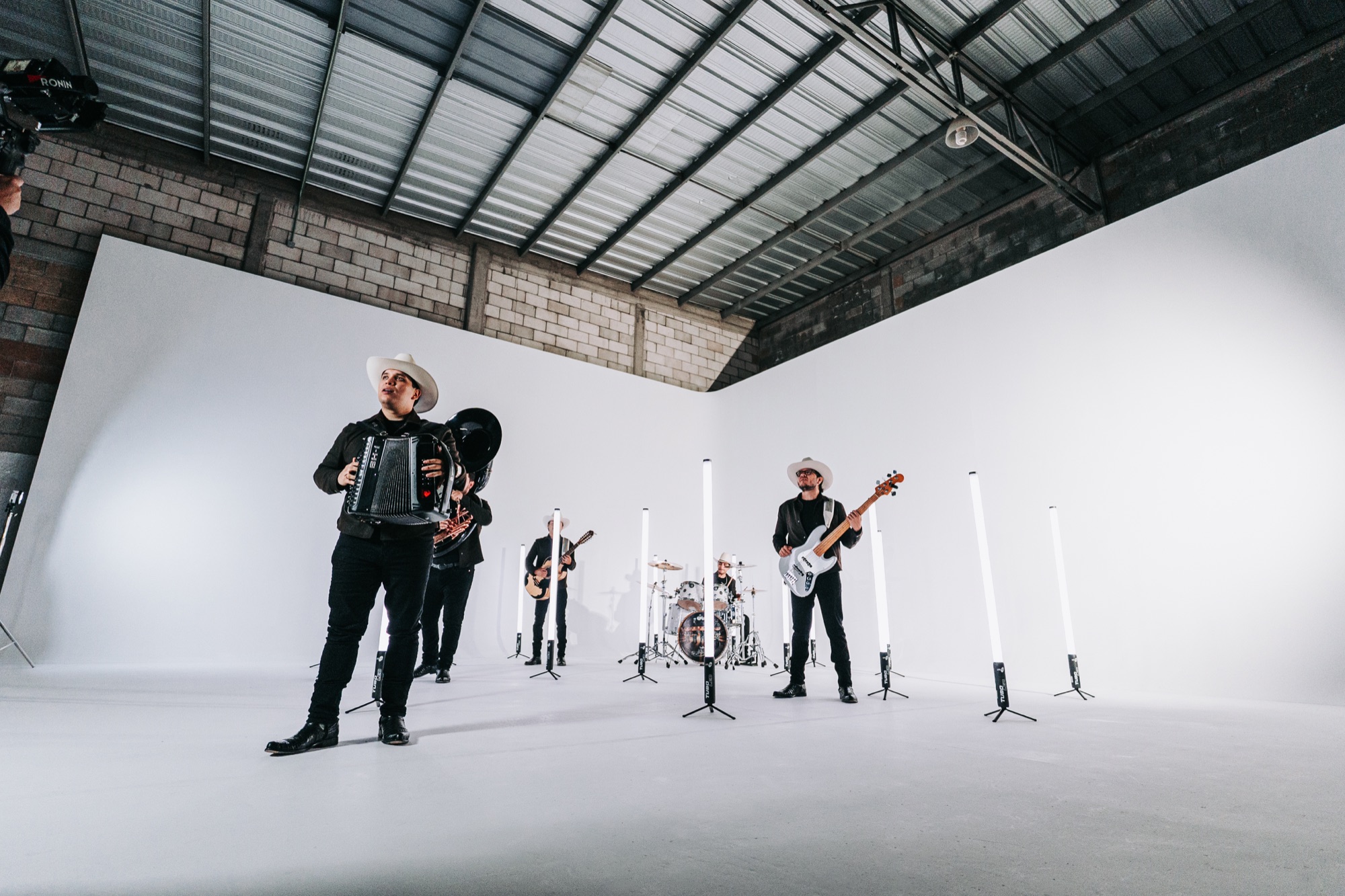 Músicos de Grupo Supremo grabando sobre el fondo blanco del foro